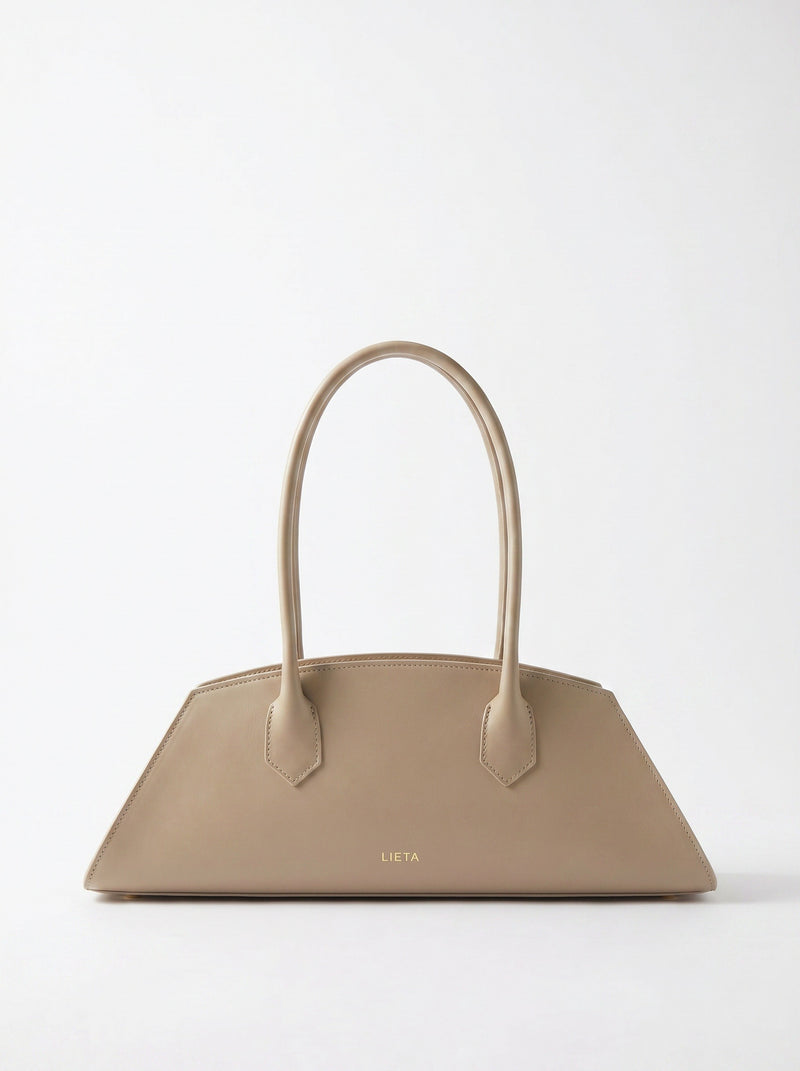 The Lungo in cream Italian calf leather on a near-white studio background — a silhouette comparable to Polène's signature pieces.