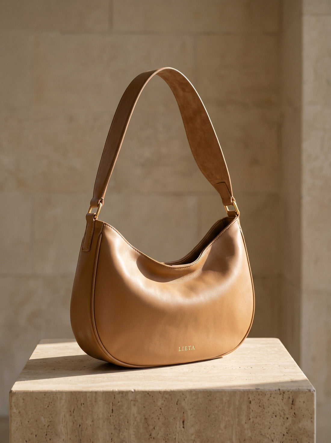 The Abbraccio in Camel — on a travertine plinth